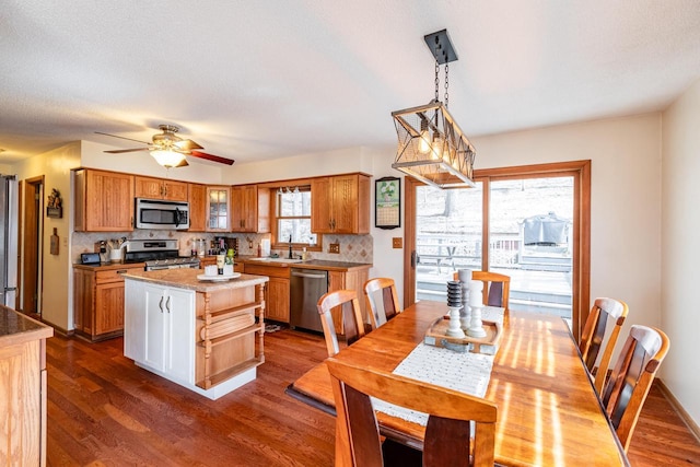 dining room with a ceiling fan and dark wood-style flooring