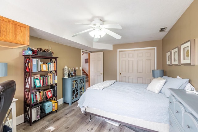 bedroom featuring visible vents, ceiling fan, baseboards, light wood-style floors, and a closet