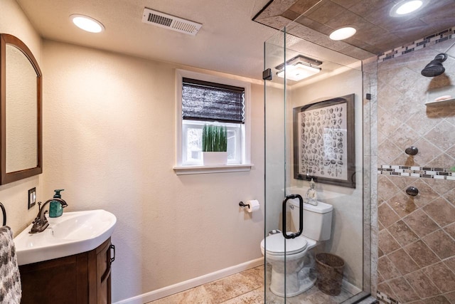 full bath with vanity, baseboards, visible vents, a tile shower, and toilet