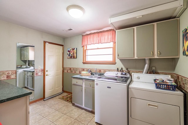 laundry room featuring visible vents, a sink, washing machine and dryer, cabinet space, and light tile patterned flooring