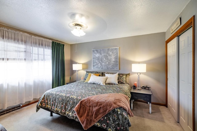 bedroom featuring a closet, baseboards, carpet, and a textured ceiling