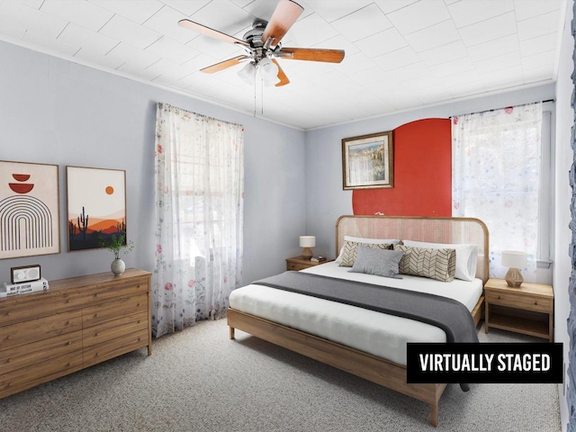 bedroom with carpet flooring, crown molding, multiple windows, and a ceiling fan