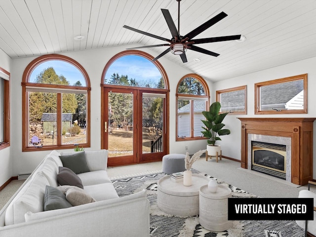 sunroom / solarium featuring a fireplace, a ceiling fan, wooden ceiling, and lofted ceiling