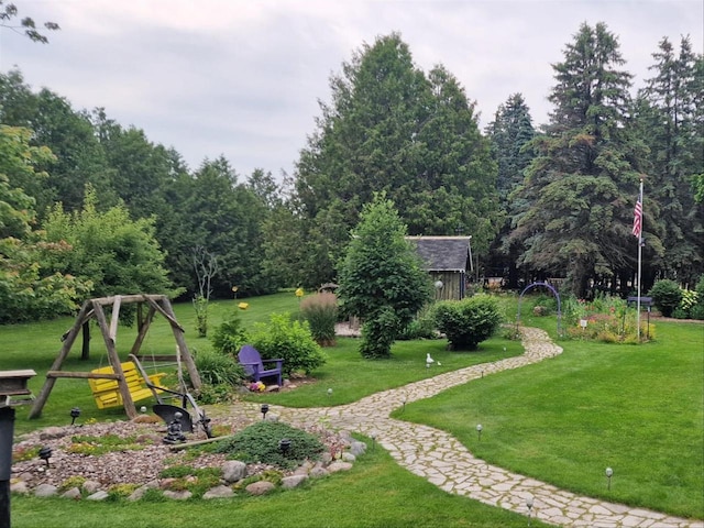 view of play area featuring an outbuilding, a yard, and a shed