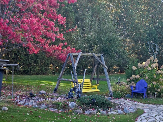 view of jungle gym with a lawn and a wooded view