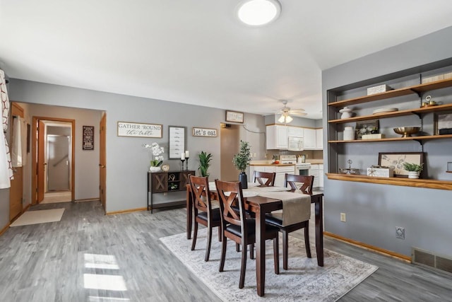 dining room featuring visible vents, ceiling fan, light wood-type flooring, and baseboards