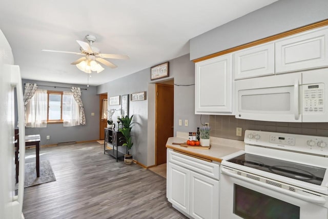 kitchen with tasteful backsplash, white appliances, light wood-style floors, white cabinets, and light countertops