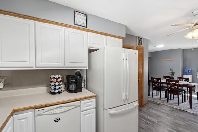 kitchen with decorative backsplash, white appliances, white cabinetry, and light countertops