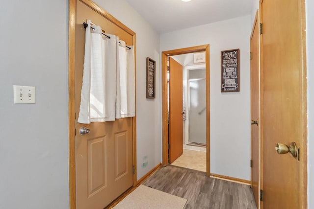 interior space featuring baseboards and wood finished floors