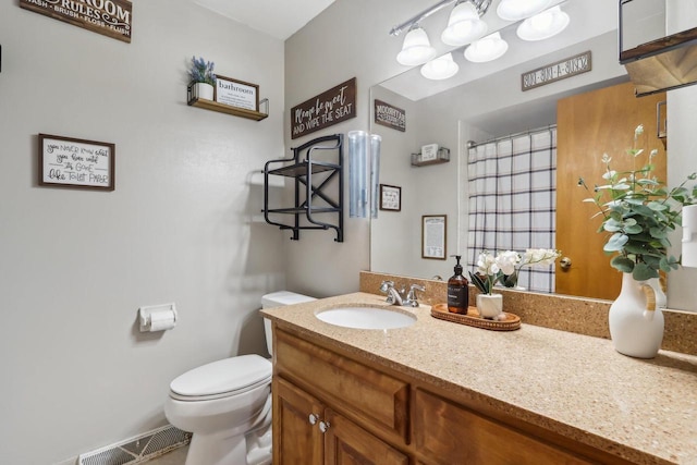 bathroom featuring visible vents, toilet, vanity, and a shower with curtain