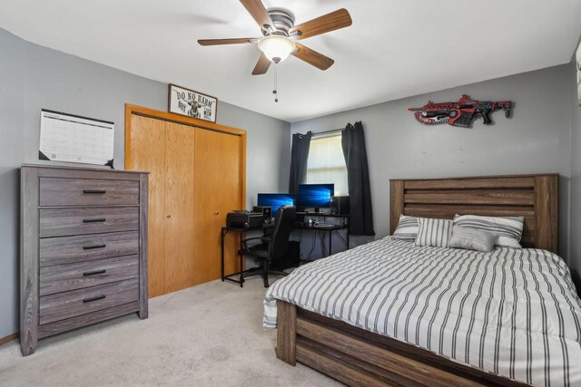 bedroom with ceiling fan, a closet, and light carpet