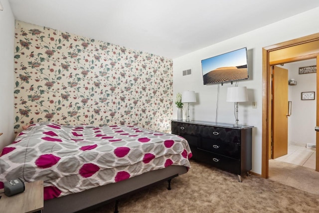 bedroom with visible vents and light carpet