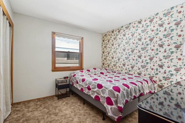 bedroom with a closet, baseboards, and carpet flooring