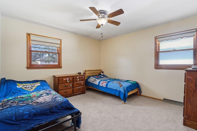 bedroom with a ceiling fan, baseboards, baseboard heating, and carpet flooring