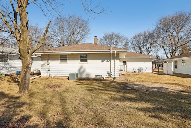 back of house with a yard, central AC, and a chimney