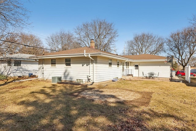 rear view of property with a lawn and a chimney