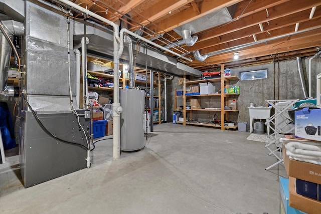 unfinished below grade area featuring a sink, heating unit, and water heater