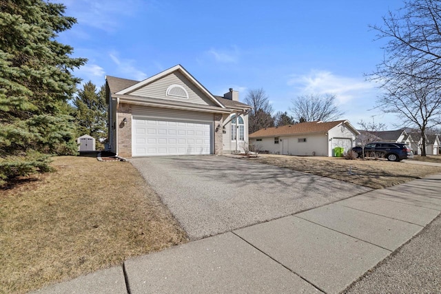 view of front facade with aphalt driveway, an attached garage, a chimney, and brick siding