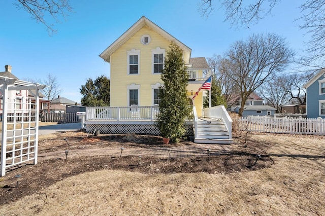 back of property featuring fence and a pergola