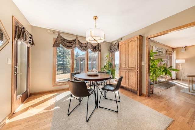 dining area with light wood-type flooring and baseboards