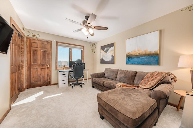 carpeted home office with baseboards and ceiling fan