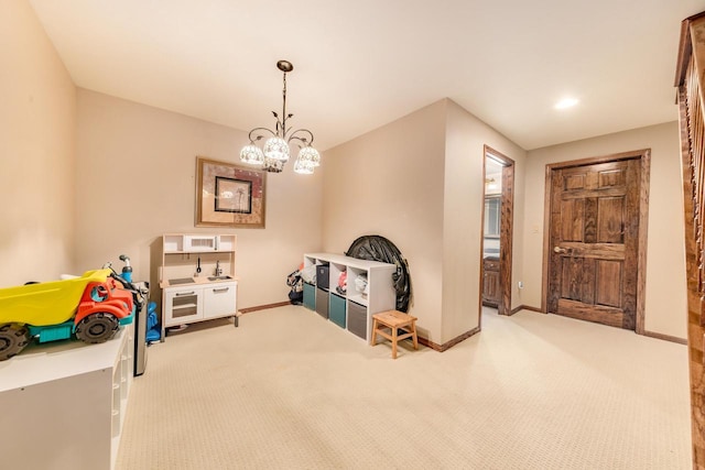 rec room with baseboards, an inviting chandelier, and carpet flooring