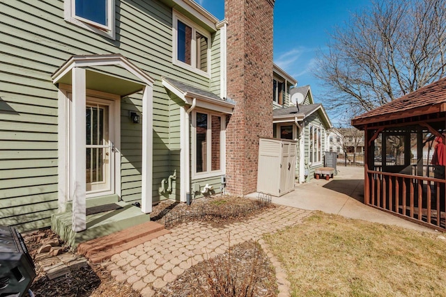 view of home's exterior with a gazebo, a chimney, and a patio