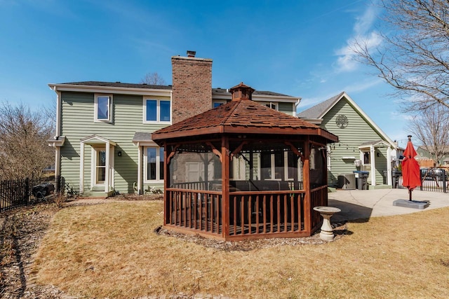 back of house featuring a patio, fence, a yard, a chimney, and a gazebo