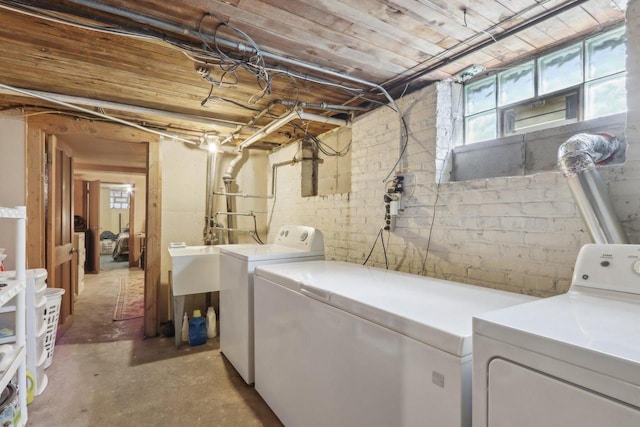 laundry area featuring washer and dryer, laundry area, and concrete block wall