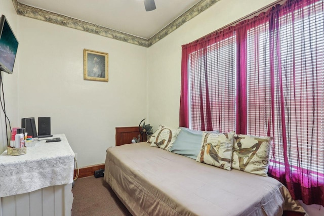 carpeted bedroom featuring a ceiling fan and baseboards