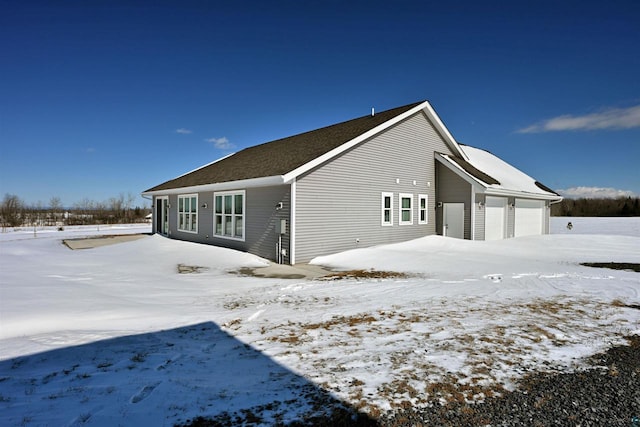 view of snow covered exterior with a garage