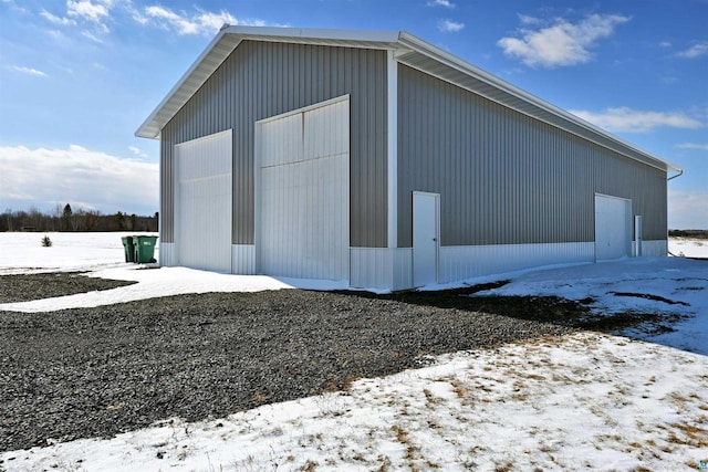 snow covered structure featuring an outbuilding