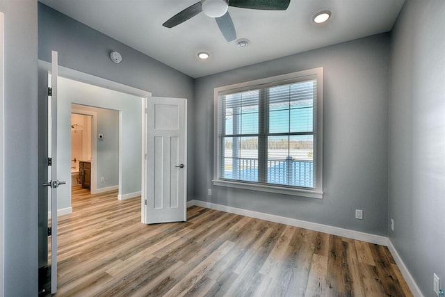 unfurnished room with baseboards, light wood-type flooring, and ceiling fan