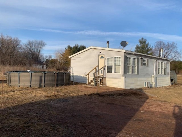 view of home's exterior featuring an outdoor pool and entry steps