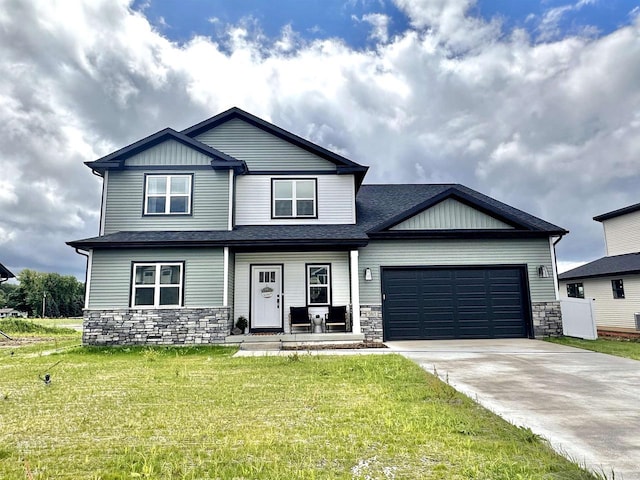 craftsman inspired home featuring stone siding, a front lawn, concrete driveway, and a garage