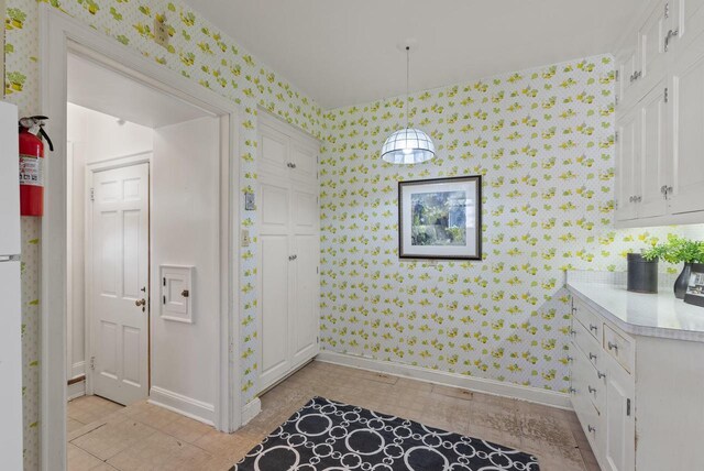 interior space with wallpapered walls and baseboards
