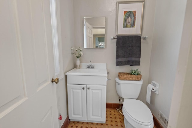 half bath with visible vents, baseboards, toilet, and vanity