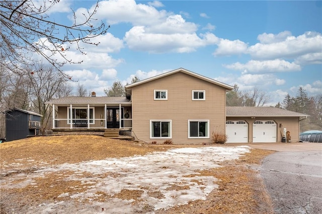 view of front of property with covered porch, driveway, and a garage