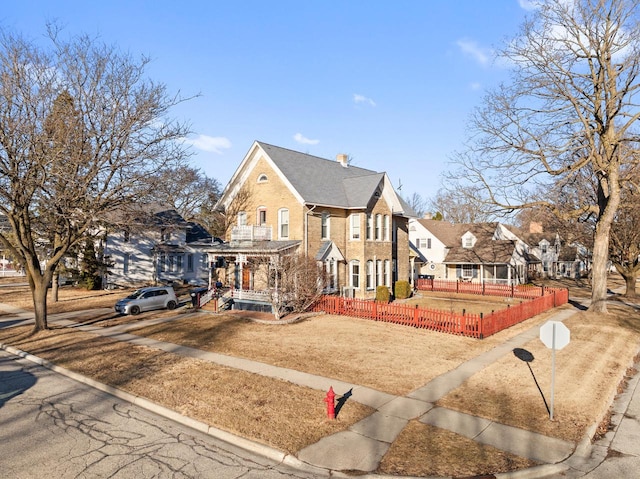 view of front of home featuring a fenced front yard and brick siding