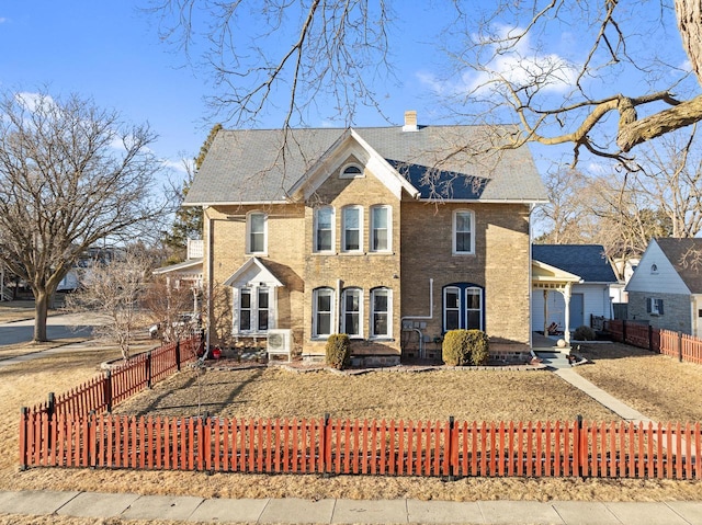 view of front of house with a chimney, fence private yard, and brick siding