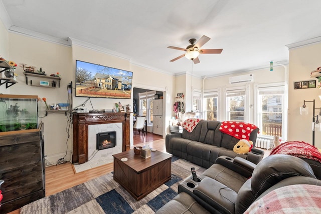 living room featuring a premium fireplace, wood finished floors, crown molding, and a wall unit AC