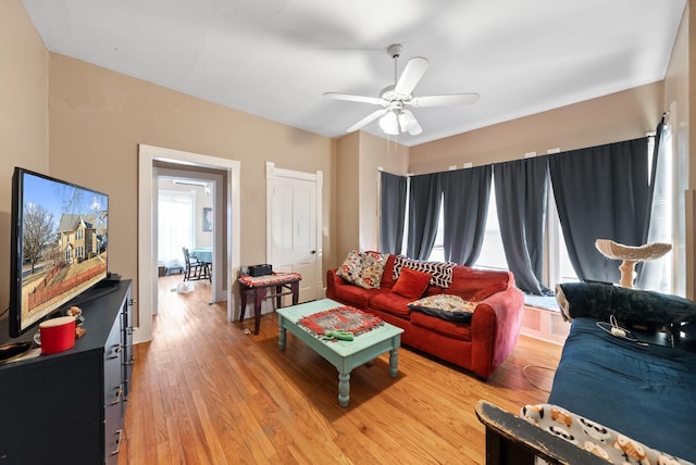 living room featuring light wood-style flooring and a ceiling fan