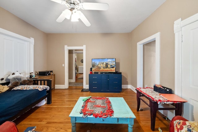 bedroom with baseboards, a ceiling fan, and light wood finished floors