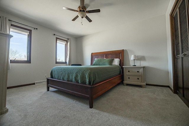 carpeted bedroom with visible vents, baseboards, a closet, and a ceiling fan