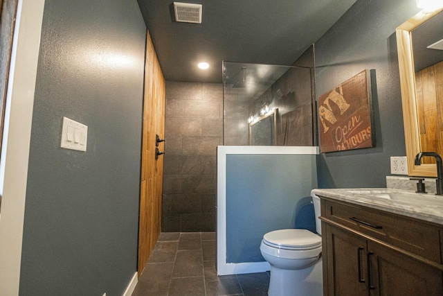 bathroom featuring visible vents, toilet, vanity, and a walk in shower