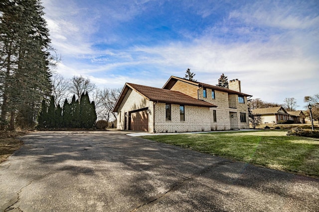 view of property exterior with aphalt driveway, a yard, an attached garage, brick siding, and a chimney