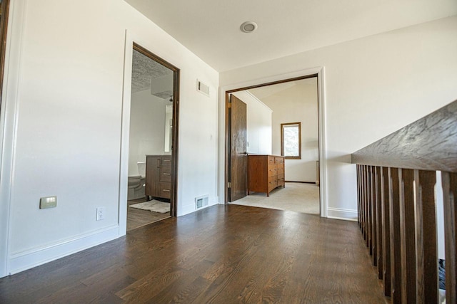 unfurnished room featuring visible vents, baseboards, and wood finished floors