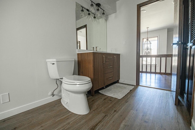 bathroom featuring toilet, wood finished floors, and baseboards