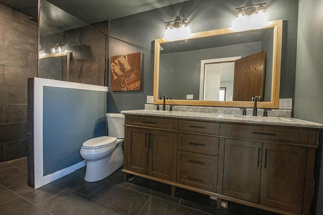 bathroom with double vanity, toilet, walk in shower, and a sink