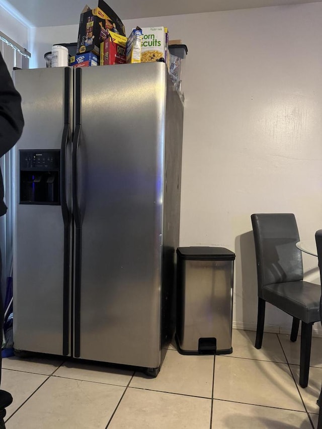 interior space featuring light tile patterned floors and stainless steel fridge with ice dispenser